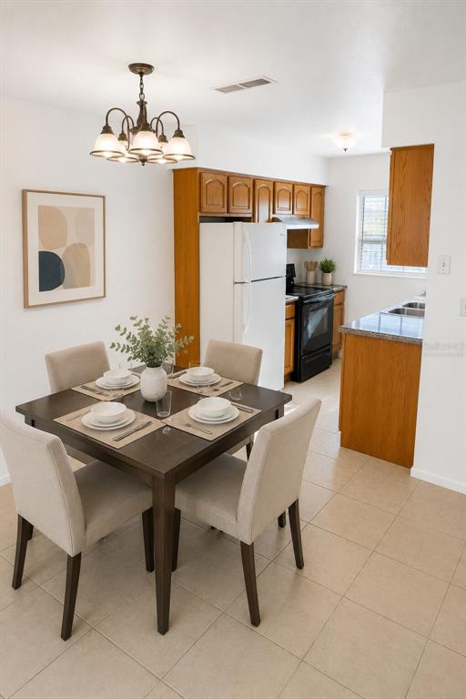 A dining area with a dark wood table and four chairs sits adjacent to a kitchen — 1400 EUDORA ROAD UNIT C32, MOUNT DORA, FL