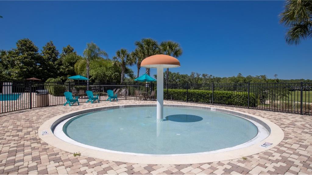 A circular wading pool with a mushroom-shaped water feature sits on a paved patio — 4464 OCHOS RIOS PLACE, KISSIMMEE, FL