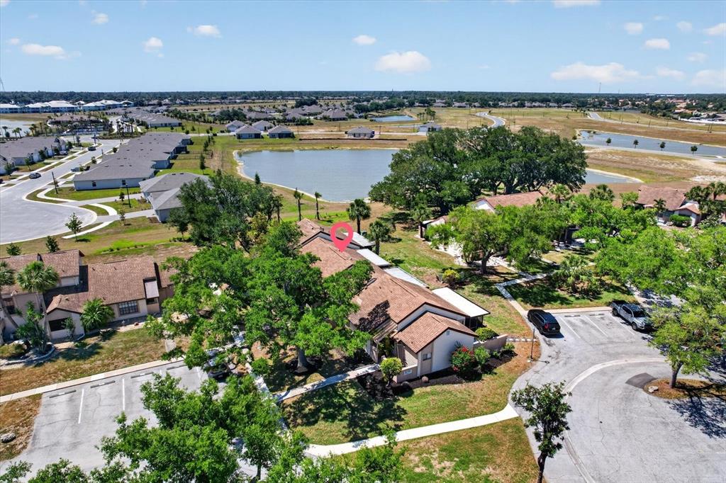 An aerial view shows a residential building with a brown roof surrounded by trees — 5261 BRASSY LOOP, NORTH PORT, FL