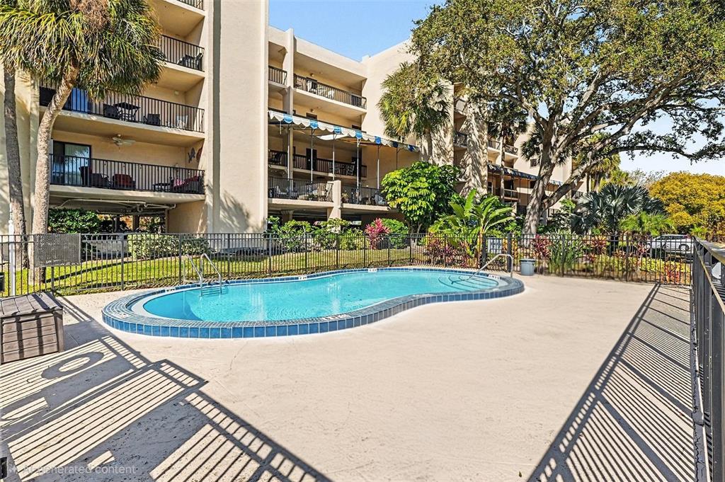 An aerial view shows a waterfront property with apartment buildings and a small wooden dock — 303 TARPON POINT, TARPON SPRINGS, FL