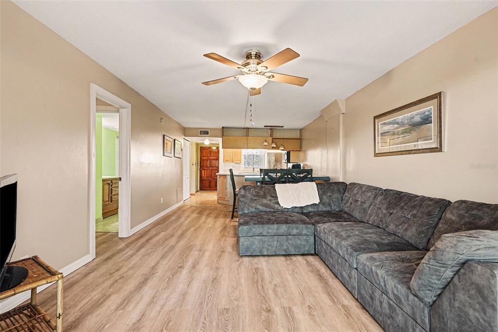 An outdoor apartment building walkway with a metal railing, stucco walls, and a screen door — 303 TARPON POINT, TARPON SPRINGS, FL