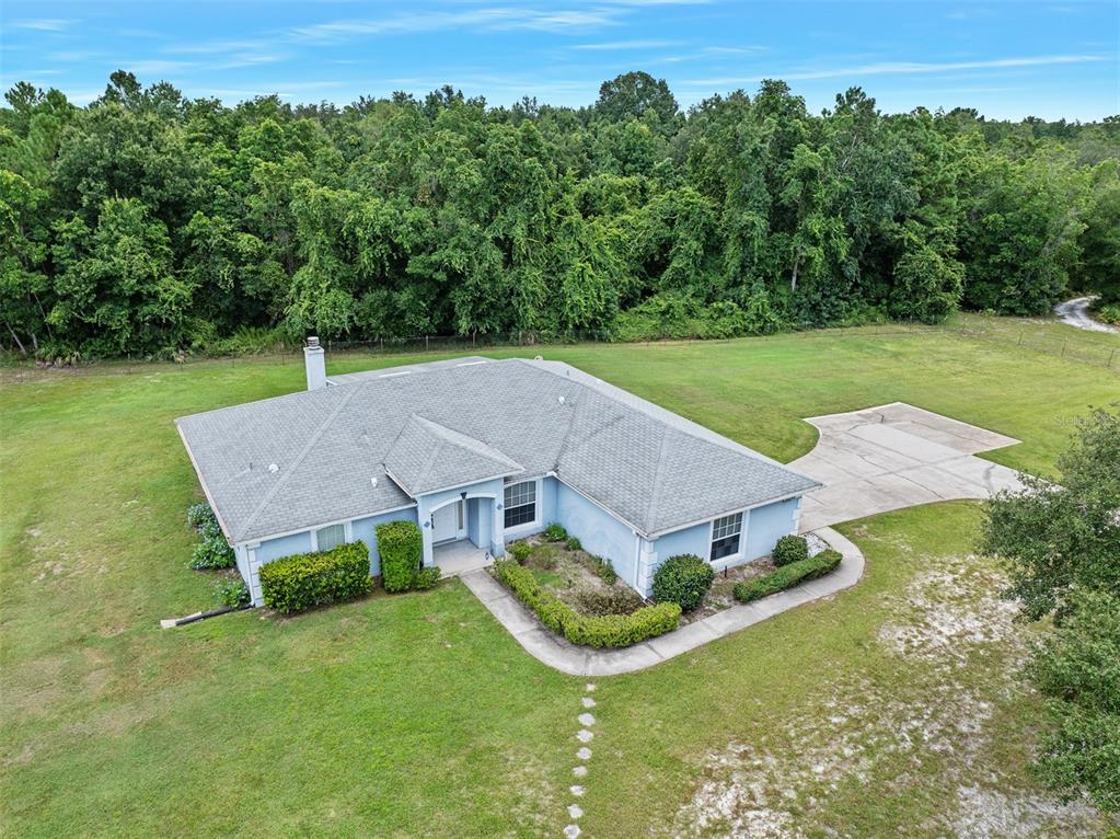 An aerial view of a light blue single-story house with a gray roof and driveway — 32543 PONDEROSA AVENUE, DELAND, FL