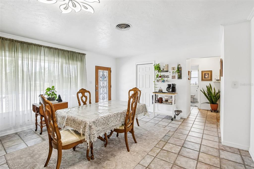 A dining room features a wooden table with chairs, tile flooring, and a coffee station — 806 BLUE HERON BOULEVARD, RUSKIN, FL