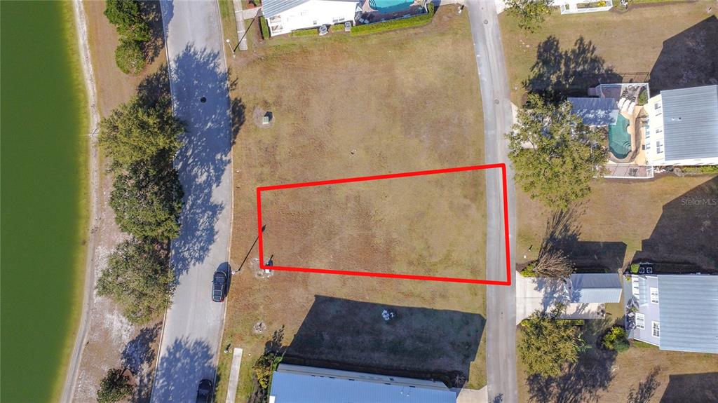 An aerial view shows a vacant, rectangular residential lot outlined in red between two roads — 1527 FAIRVIEW CIRCLE, REUNION, FL