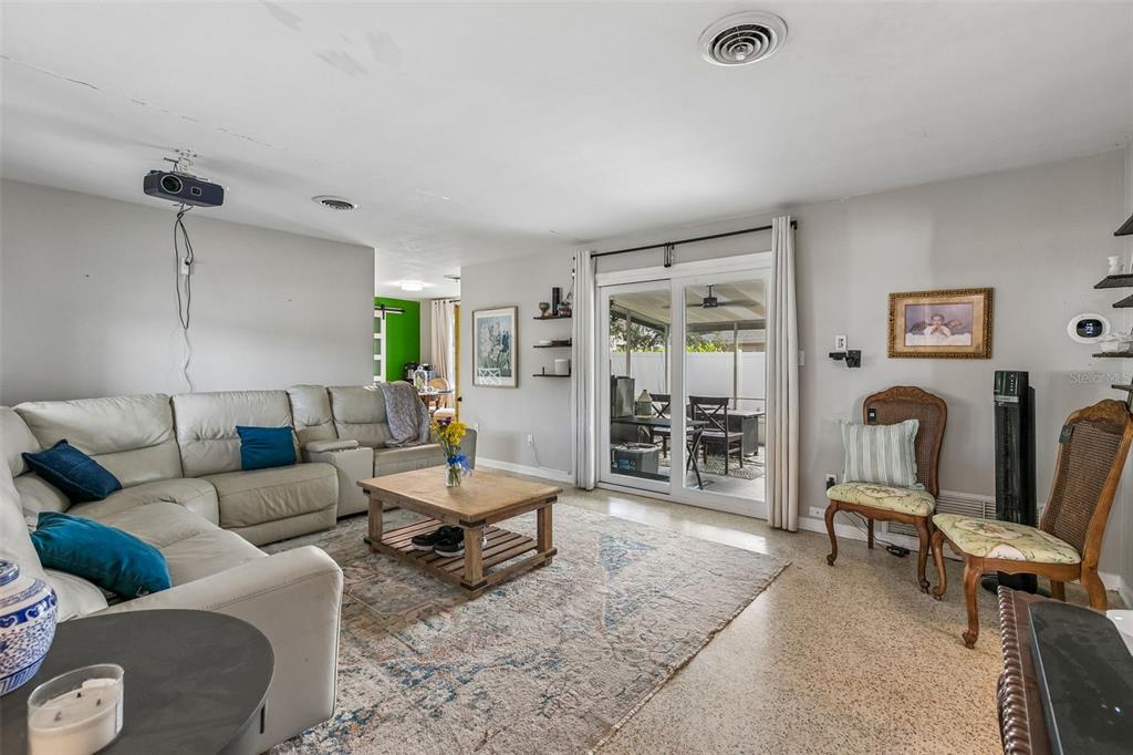A living room features a large beige sectional sofa, a wooden coffee table, and a projector — 4517 FETROW DRIVE, ORLANDO, FL