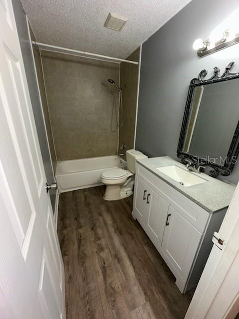 A bathroom features a white vanity, a toilet, and a shower-tub combination with wood-look flooring — 2000 SE 40TH STREET ROAD, OCALA, FL