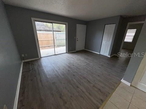 A living room with gray walls, wood-look flooring, a sliding glass door, and a closet — 2000 SE 40TH STREET ROAD, OCALA, FL