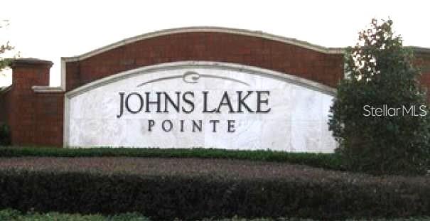 A brick and stone monument sign displays the name Johns Lake Pointe — 745 MARSH REED DRIVE W, WINTER GARDEN, FL