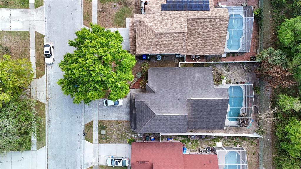 An aerial view shows three suburban houses with swimming pools and driveways along a street — 4381 CREEKSIDE BOULEVARD, KISSIMMEE, FL