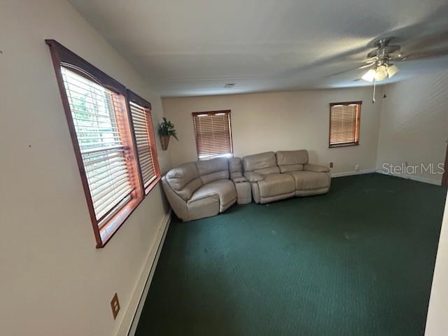 A living room features green carpeting, a beige sectional sofa, and windows with wood blinds — 526 KINGS CREEK CIRCLE, STEINHATCHEE, FL