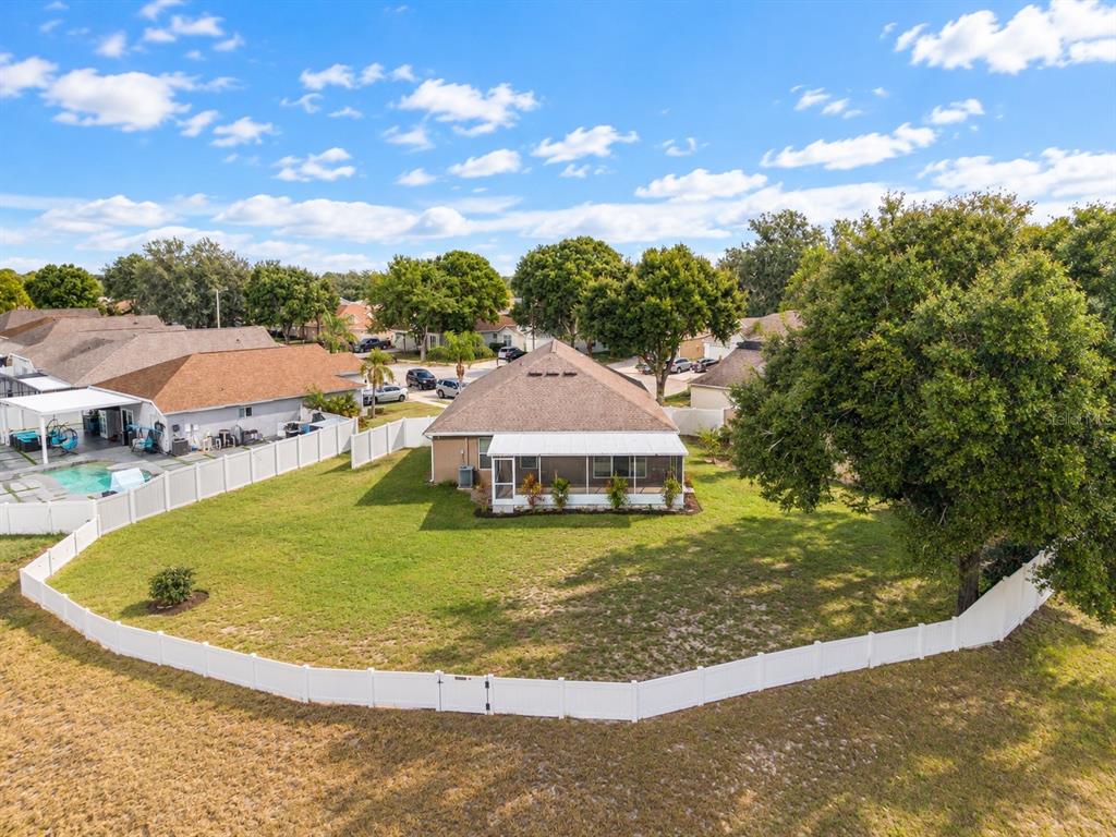 An aerial view shows a single-story house with a large fenced backyard and swimming pool — 12315 TWINKLING STAR PLACE, RIVERVIEW, FL