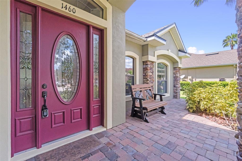 A front entryway features a magenta door with glass inserts and a stone-paved porch — 1460 PRAIRIE OAKS DRIVE, ST CLOUD, FL