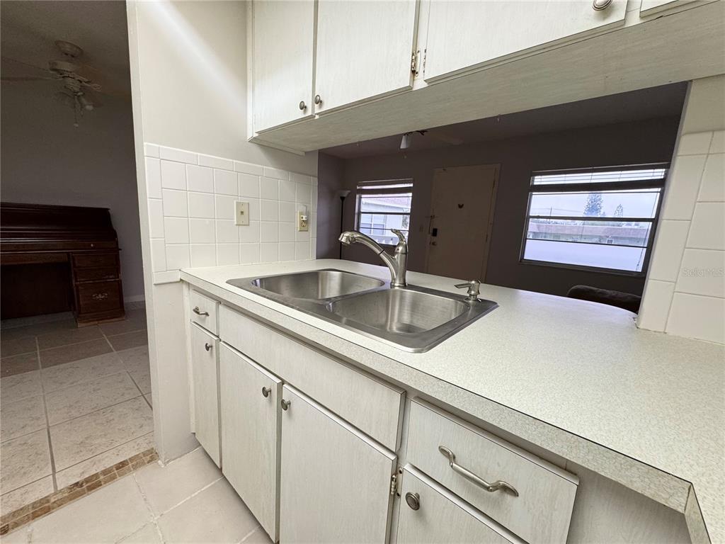 A living room features a beige sofa, a wooden coffee table, and tiled flooring — 1250 S PINELLAS AVENUE UNIT 511, TARPON SPRINGS, FL