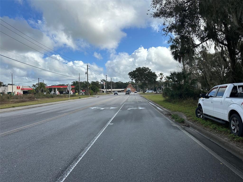A view of a paved road with a white truck parked on the right shoulder — DOYLE ROAD, OSTEEN, FL