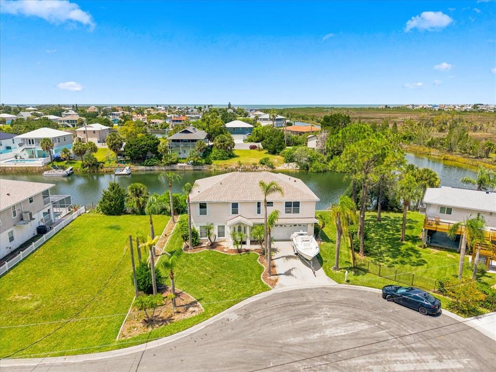 An aerial view of a two-story house with a boat in the driveway and canal — 3417 FERNLEAF DRIVE, HERNANDO BEACH, FL