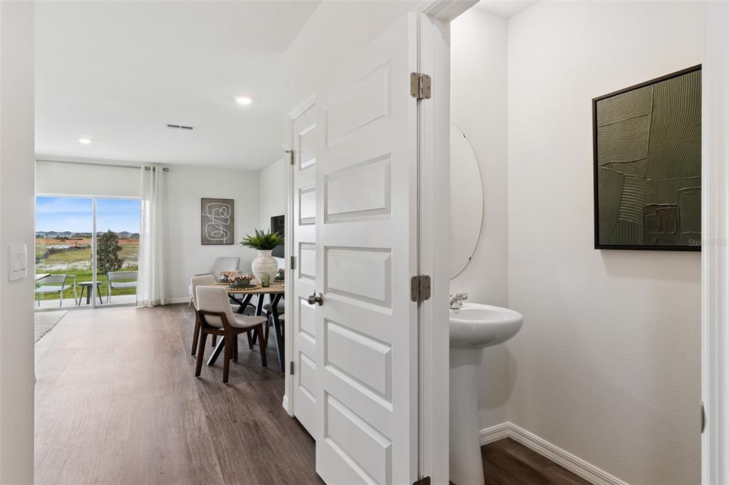 A view from a small bathroom looking out into a dining area with sliding glass doors — 4266 BUTTERSCOTCH CIRCLE, LAKELAND, FL
