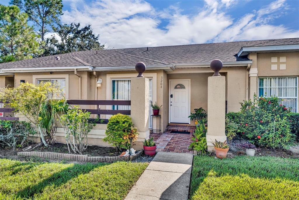 A single-story house exterior at dusk with a paved walkway leading to the front entrance — 3204 TIDEWATER DRIVE, KISSIMMEE, FL