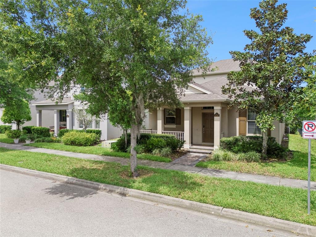 A tan two-story house with a front porch, trees, and a no-parking sign — 16197 WIND VIEW LANE, WINTER GARDEN, FL