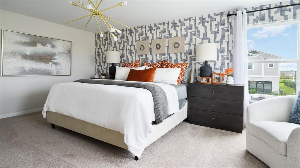 A bedroom features a patterned accent wall, a gold chandelier, and a large bed — 36676 THORNHEDGE DRIVE, ZEPHYRHILLS, FL