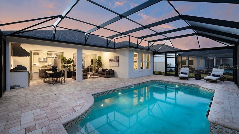 An open-concept living room and kitchen featuring a large sofa, wood coffee table, and island — 1003 TASSLEFLOWER TRAIL, ST CLOUD, FL