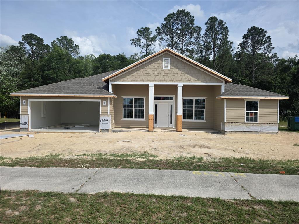 This architectural rendering shows the front elevation of a single-story house with a stone base — 247 SW BELLFLOWER DRIVE, LAKE CITY, FL