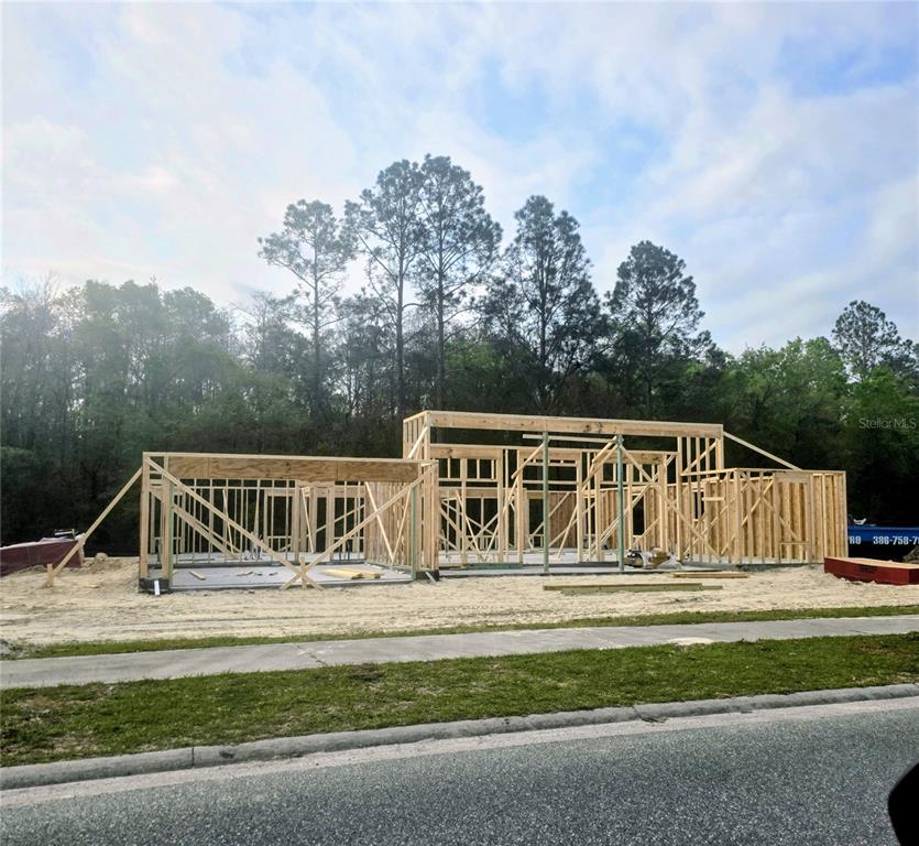 A kitchen features white cabinets, granite countertops, a double sink, and tile flooring — 247 SW BELLFLOWER DRIVE, LAKE CITY, FL