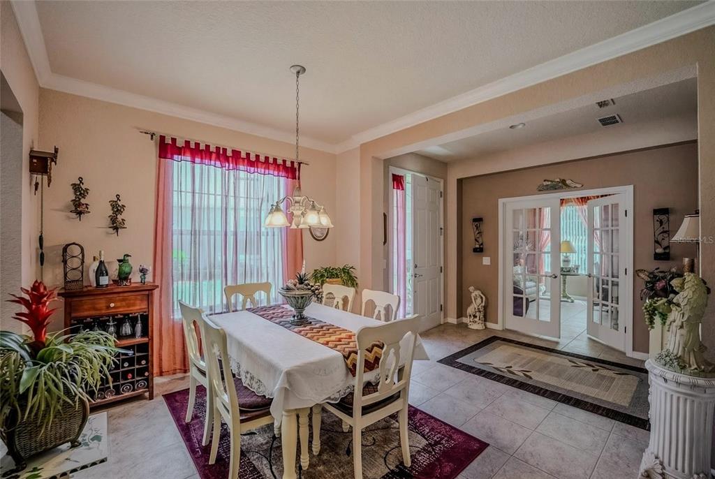 A dining room with a table, chairs, tile flooring, and French doors leading to another room — 9077 SW 70TH LOOP, OCALA, FL