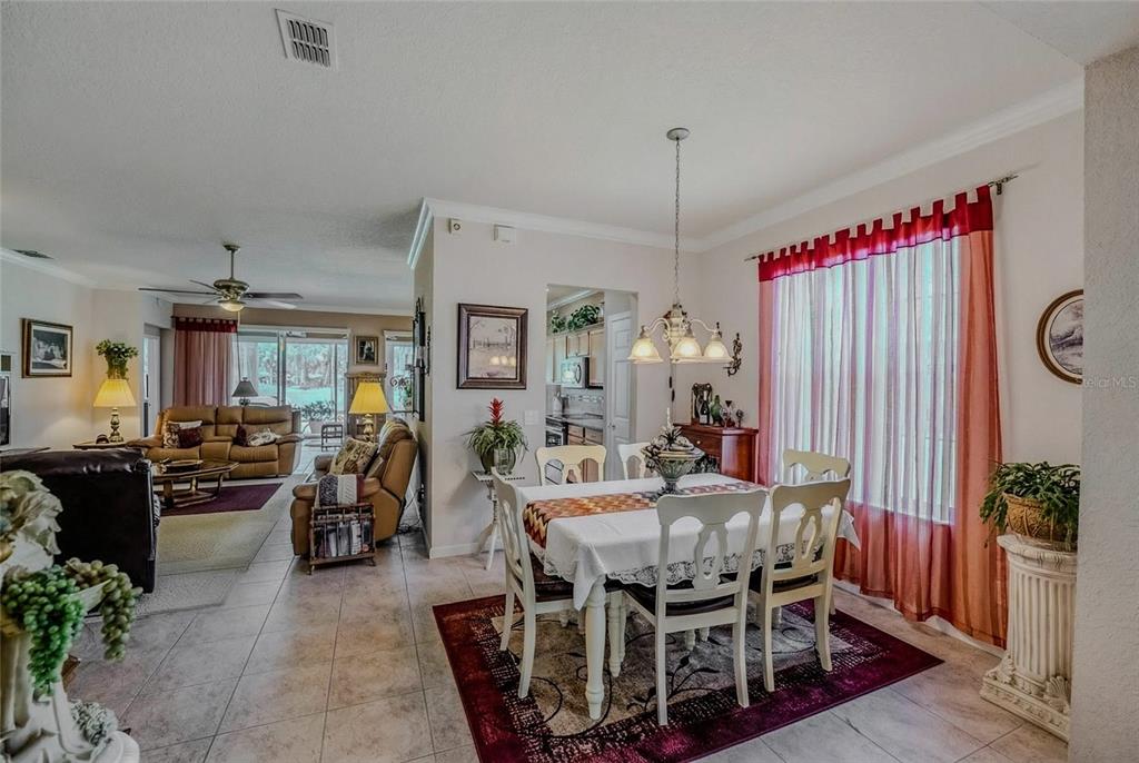 A dining area with a white table and chairs sits adjacent to a living room — 9077 SW 70TH LOOP, OCALA, FL