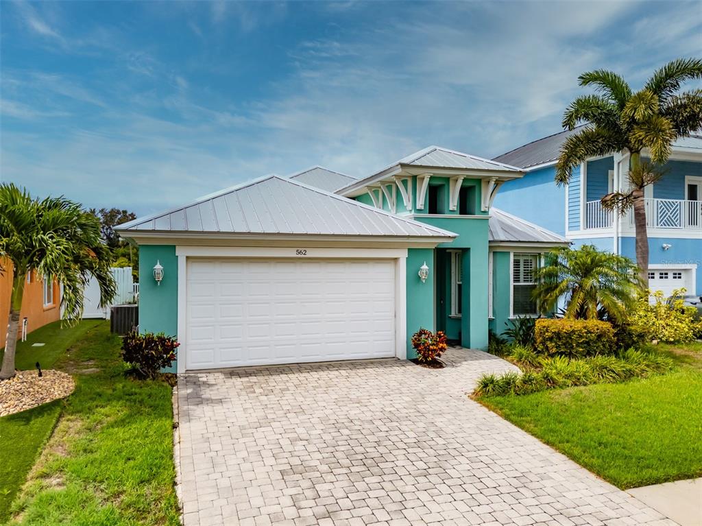 A teal house with a metal roof and a white garage door faces a driveway — 562 BIMINI BAY BOULEVARD, APOLLO BEACH, FL