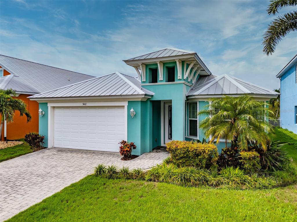 A teal, single-story house with a metal roof and a white two-car garage — 562 BIMINI BAY BOULEVARD, APOLLO BEACH, FL