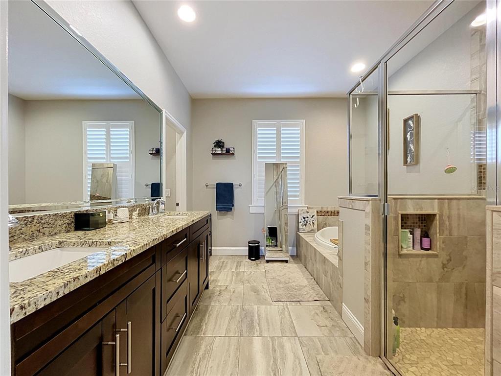 A single-story house with a gray garage, a paved driveway, and a covered front porch — 6104 HIGHLANDS GRACE BOULEVARD, LAKELAND, FL