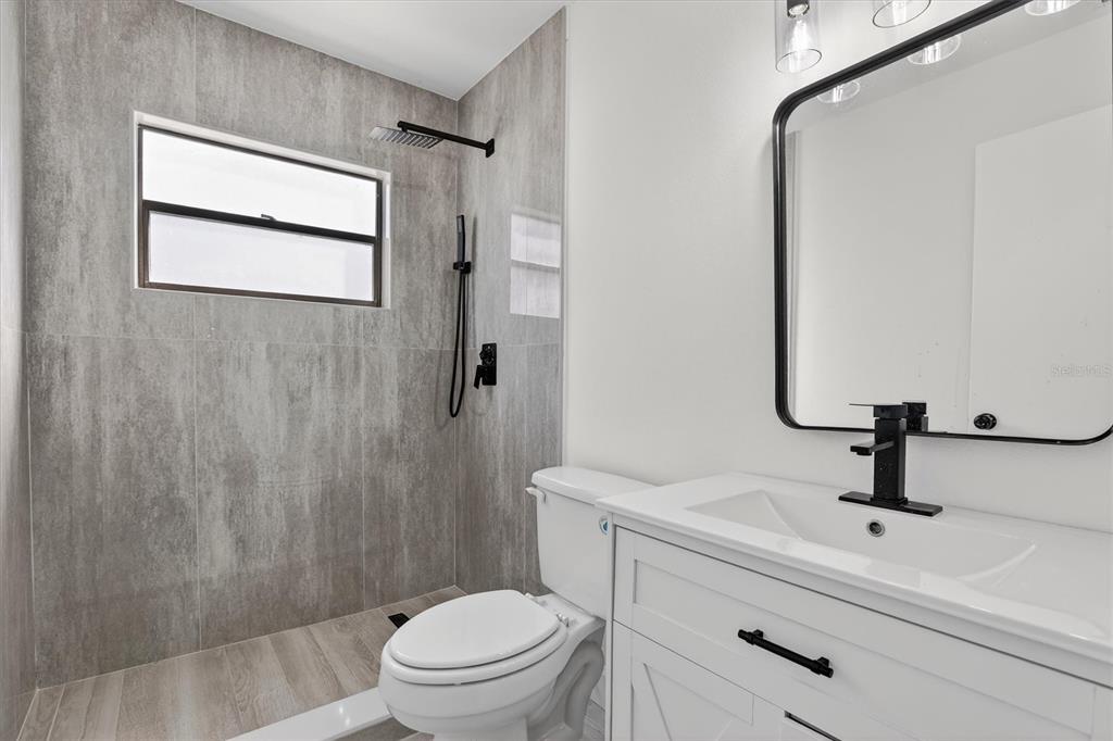 A bathroom features a walk-in shower with gray tile, a white vanity, and black fixtures — 517 HICKORYWOOD AVENUE, ALTAMONTE SPRINGS, FL