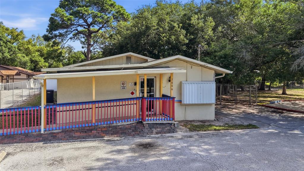 A single-story building with a wheelchair ramp and a large paved parking lot — 2886 WHITNEY ROAD, CLEARWATER, FL