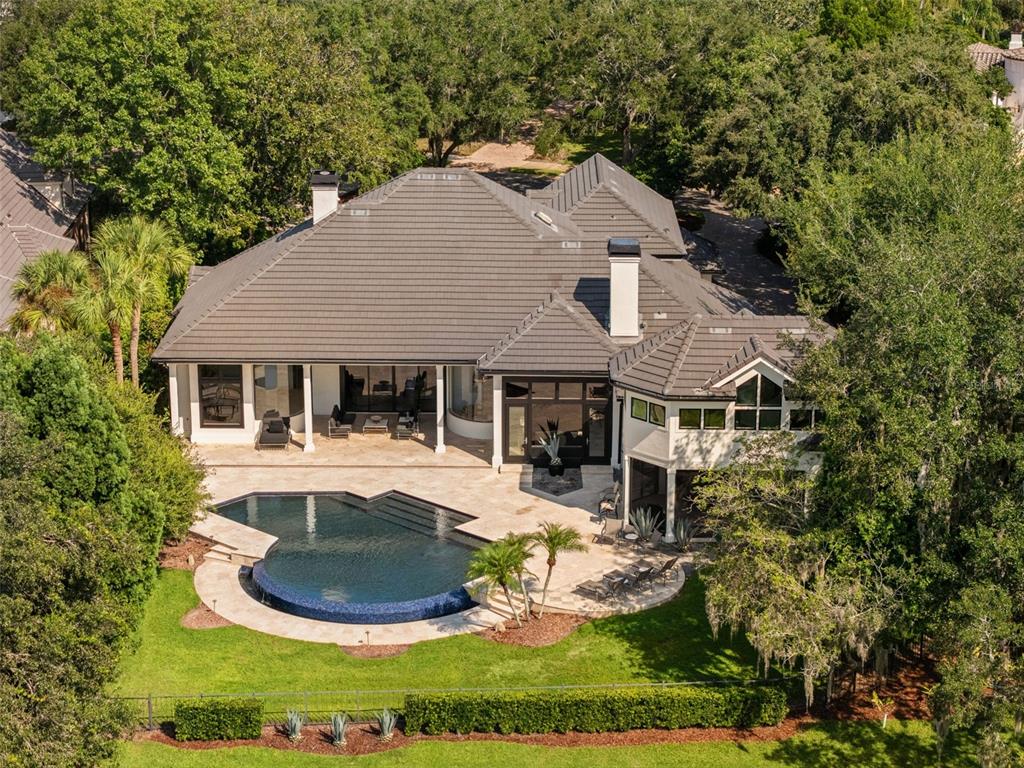 An aerial view of a house with a tiled roof, swimming pool, and landscaped backyard — 9222 SLOANE STREET, ORLANDO, FL