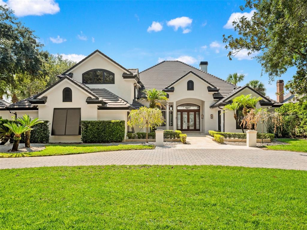 A white stucco house with a dark tile roof and a paved driveway — 9222 SLOANE STREET, ORLANDO, FL