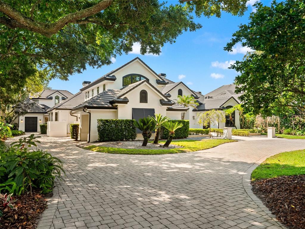 A large white house with a dark tile roof and a paved circular driveway — 9222 SLOANE STREET, ORLANDO, FL