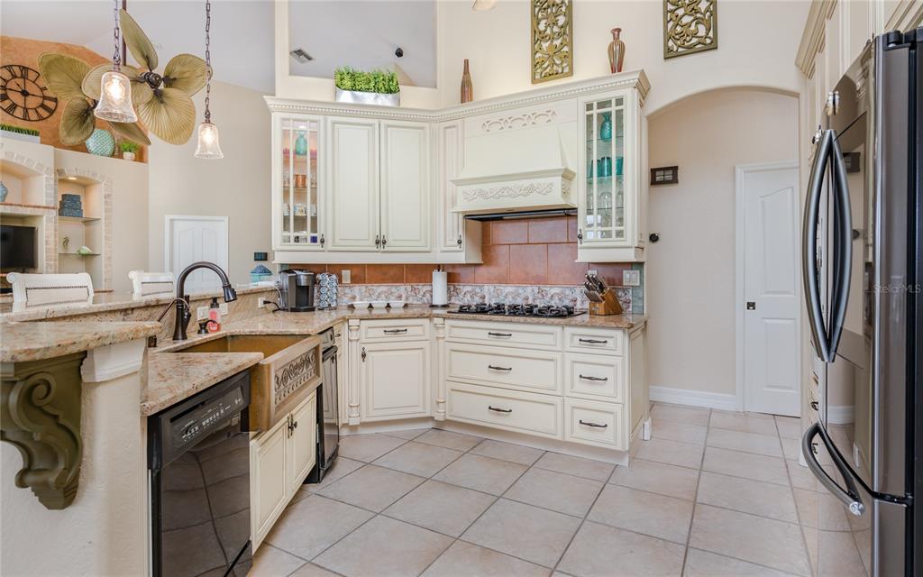 A kitchen with cream cabinets, granite countertops, a farmhouse sink, and stainless steel appliances — 2317 SW 43RD LANE, CAPE CORAL, FL