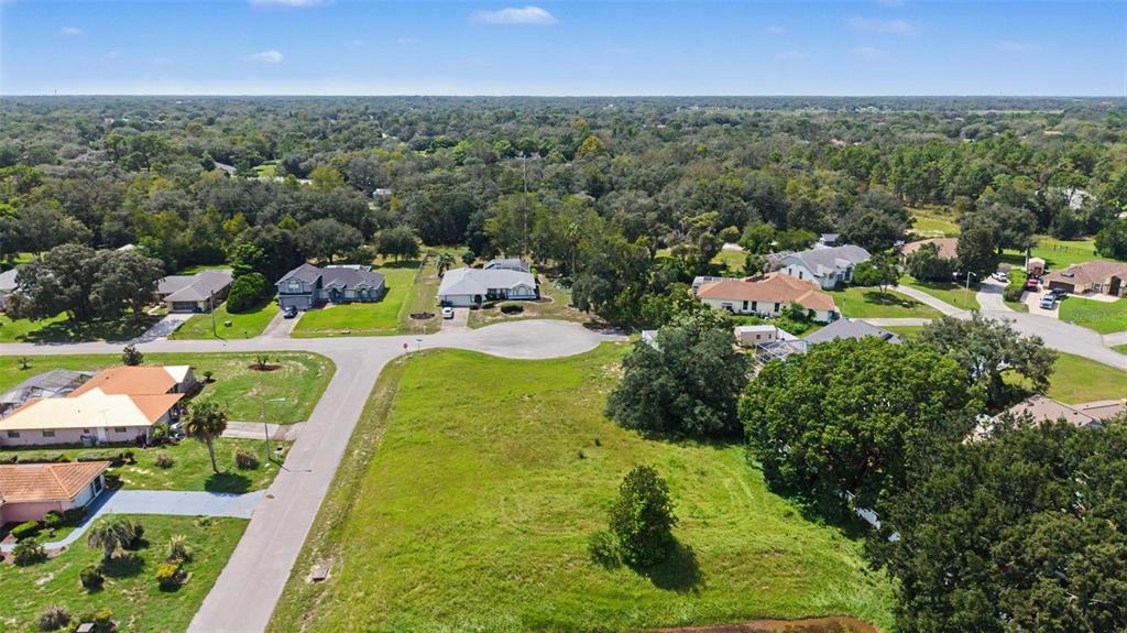 An aerial view shows a vacant grassy lot situated within a suburban residential neighborhood — NORTHWIND COURT, SPRING HILL, FL