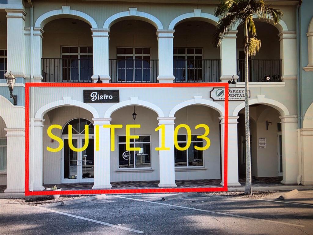 The exterior of a commercial building features a ground-level storefront with arched entryways and columns — 3976 DESTINATION DRIVE UNIT 103, OSPREY, FL