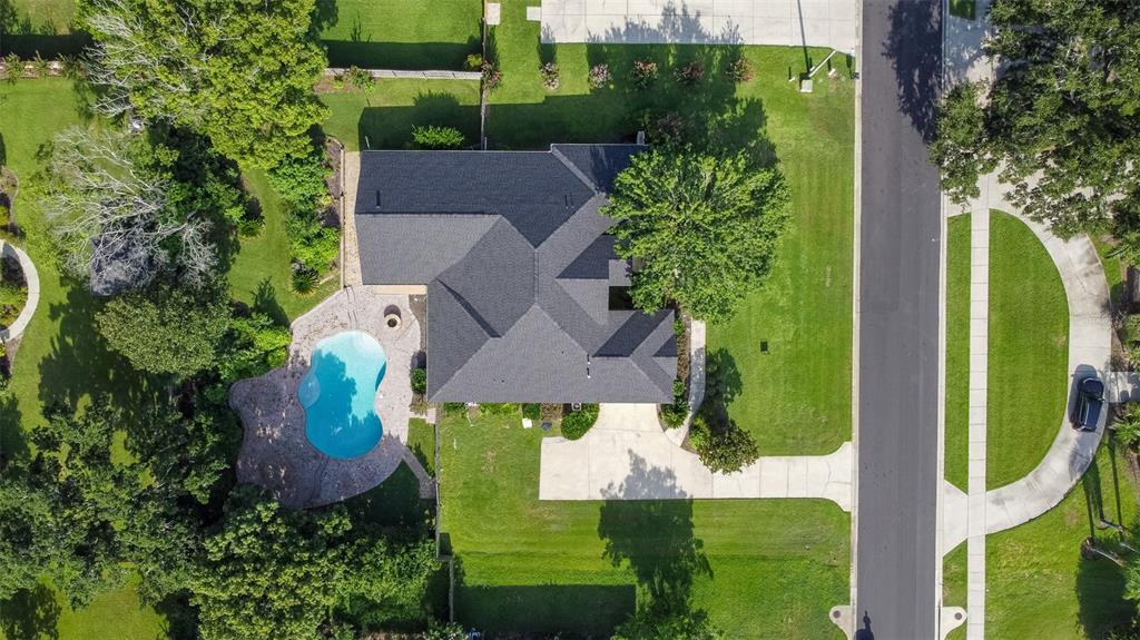 An aerial view shows a house with a dark roof, a pool, and a circular driveway — 4818 SE 11TH PLACE, OCALA, FL