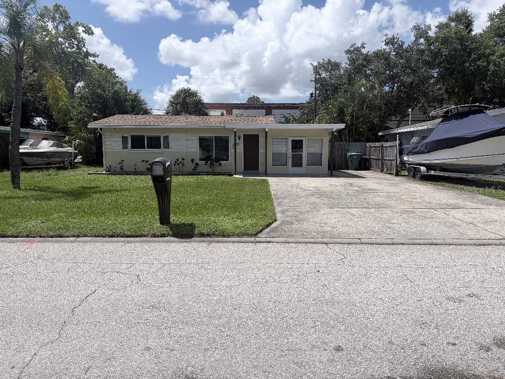 A single-story house with a concrete driveway and two boats parked on the property — 2209 EUCLID CIRCLE S, CLEARWATER, FL