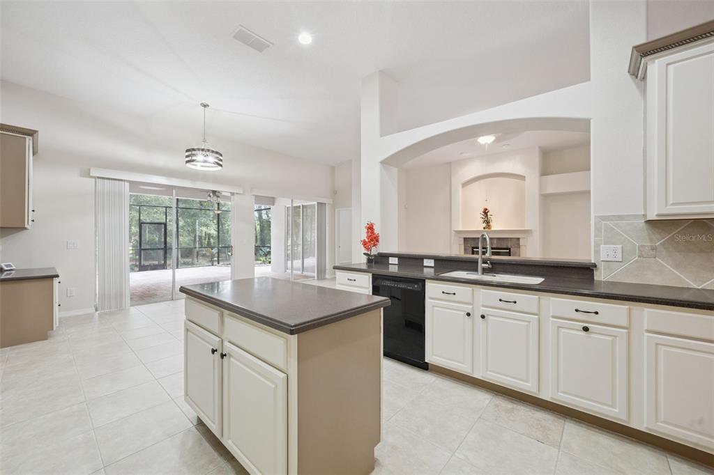 A covered patio with a brick floor, outdoor dining set, fire pit, and seating area — 597 SAND WEDGE LOOP, APOPKA, FL