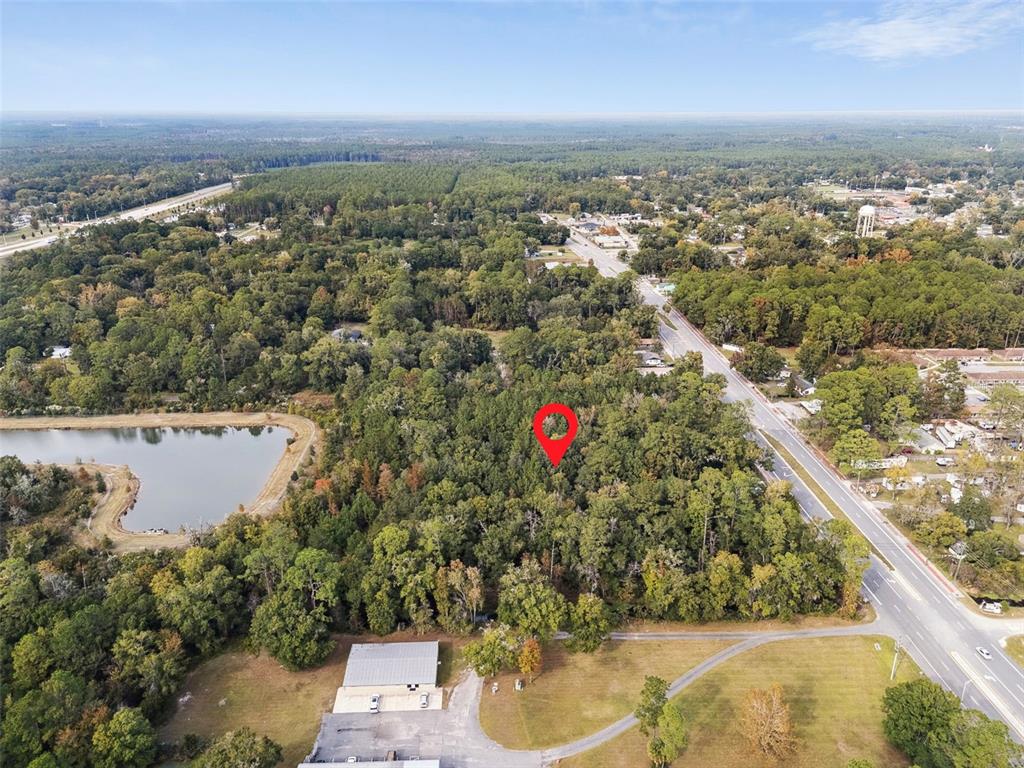 An aerial view shows a wooded lot marked with a red pin near a road — 660 US HIGHWAY 301 S, BALDWIN, FL