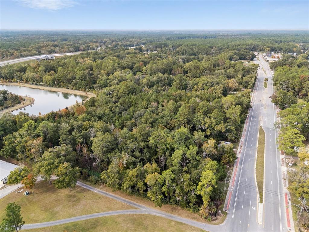 An aerial view shows a wooded lot situated between a road and a small pond — 660 US HIGHWAY 301 S, BALDWIN, FL