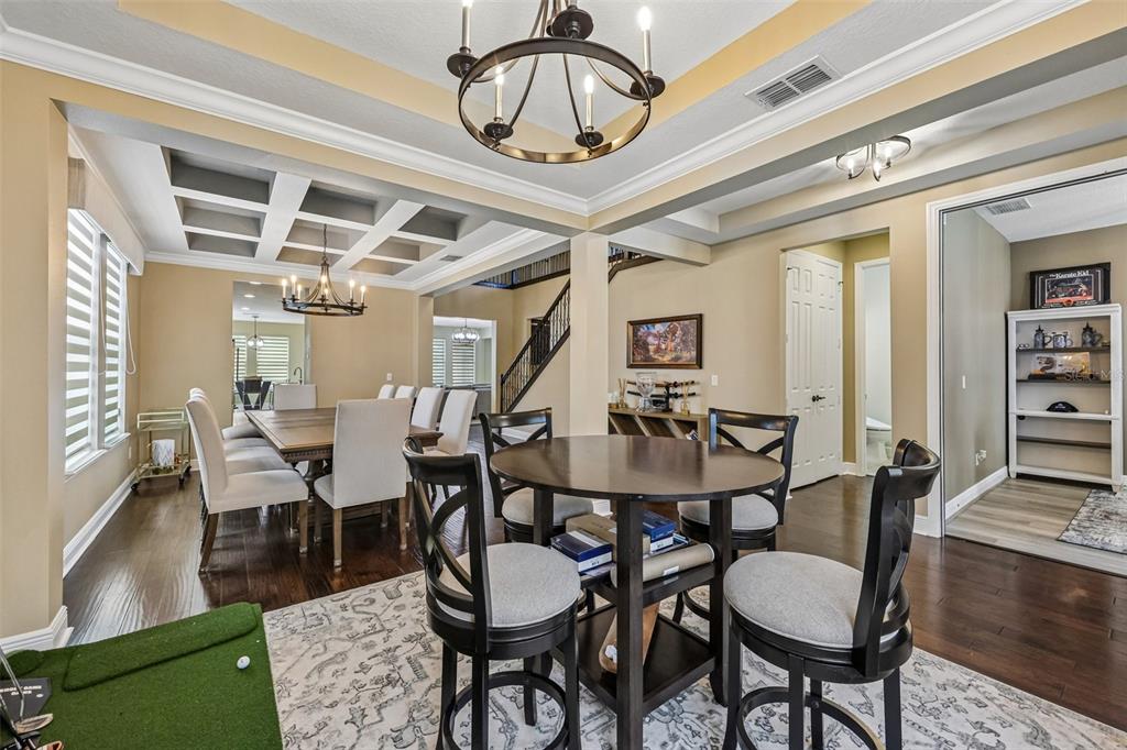 A dining area with a coffered ceiling and a separate round table with four chairs — 9117 OUTLOOK ROCK TRAIL, WINDERMERE, FL
