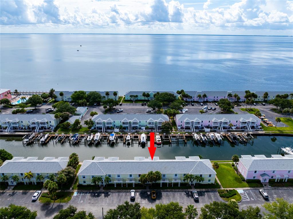 An aerial view shows a waterfront condominium complex with boat slips and a parking lot — 5132 BEACH DRIVE SE UNIT C, ST PETERSBURG, FL