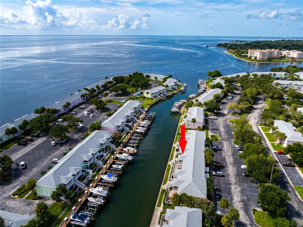 An aerial view shows a waterfront condominium complex with boat slips along a canal — 5132 BEACH DRIVE SE UNIT C, ST PETERSBURG, FL
