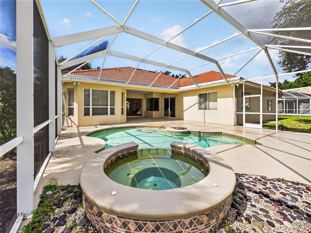 A single-story house with a tile roof, three-car garage, and a palm tree in front — 10207 ESTUARY DRIVE, TAMPA, FL