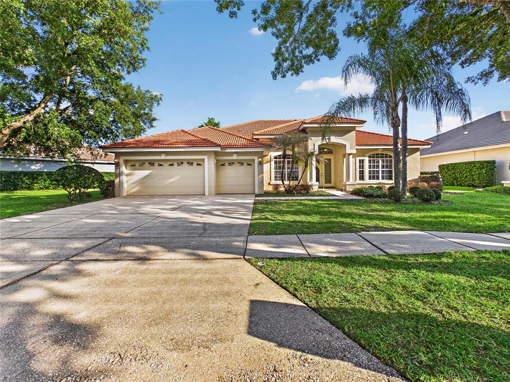 A single-story house with a tile roof, three-car garage, and a concrete driveway — 10207 ESTUARY DRIVE, TAMPA, FL