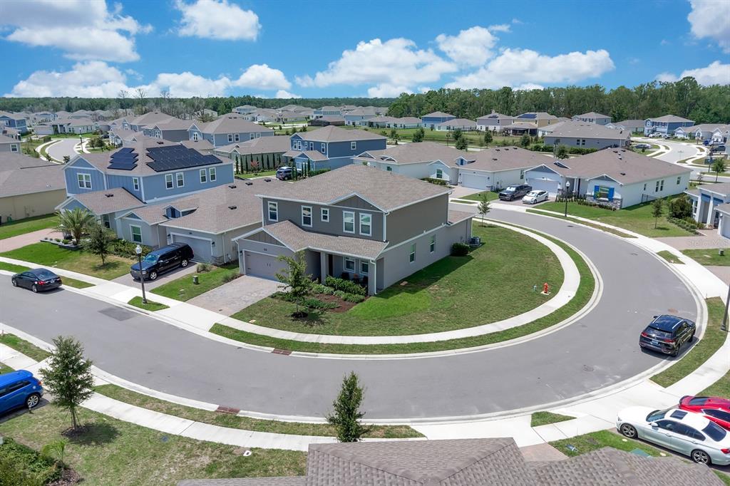 An aerial view shows a suburban neighborhood with houses, driveways, and a curved street — 4064 REDBRIDGE LOOP, DAVENPORT, FL